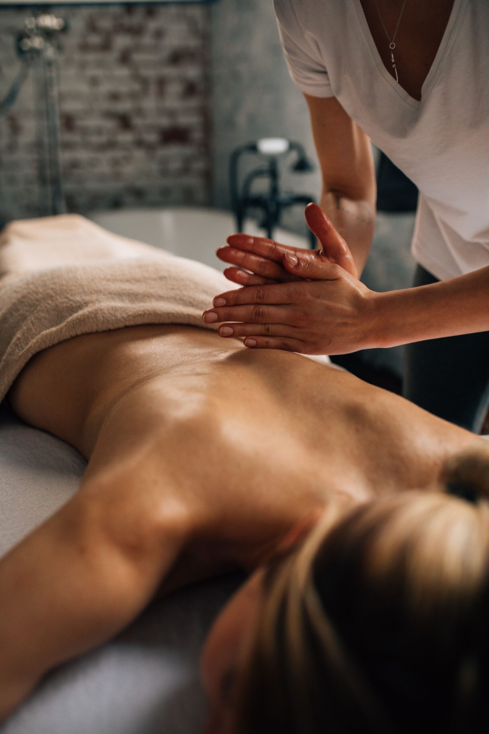 Masseuse applying massage technique to client